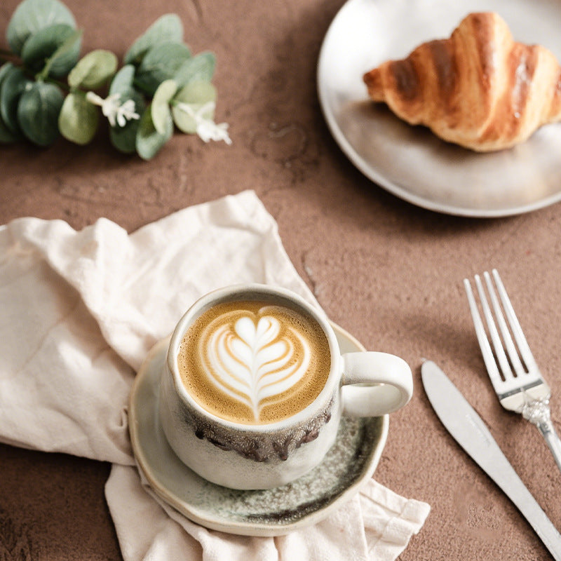 Hand-sculpted retro-style ceramic coffee cup with a large, rounded pottery saucer